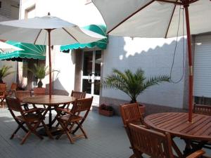 桑亨霍拜萨斯酒店的庭院里配有两张桌子和椅子以及遮阳伞