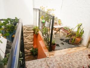 奥兰太坦波Casa Patacalle的阳台种有盆栽植物,配有桌子和栏杆