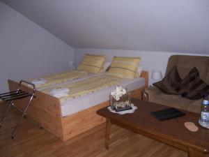 Bechtheim施耐德旅馆的一间卧室配有一张床、一张沙发和一张桌子
