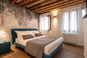 威尼斯La Finestra sulle Beccarie的一间卧室设有一张床和两个窗户。