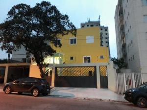 圣保罗Hotel Casa Ocarina的停在黄色建筑前面的黑色汽车