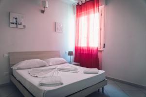 比萨Pisacentro Guest House的一间卧室配有一张带红色窗帘的床