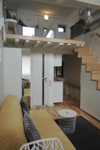 考纳斯Jolie Apartments的带沙发和楼梯的客厅