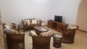 马埃岛Anse Royale Bay View Apartments的客厅配有藤椅和电视