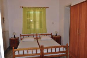 爱琴娜岛Aegina town, summer house的一间卧室设有两张床和绿帘