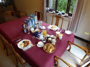 EdlingtonAt Last Bed & Breakfast的紫色桌子上摆着早餐食品