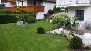 珀丽Ferienwohnung Guth的庭院里种有白色花卉和植物的花园