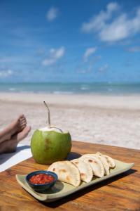 圣米格尔-杜斯米拉格里斯Pousada da Amendoeira的海滩桌子上放着苹果和面包片