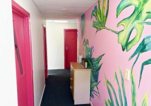惠灵顿特列全球背包客旅馆的走廊上挂着粉红色的墙壁,上面有植物