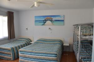 黄金海岸旭日汽车旅馆的客房设有三张双层床和吊扇。