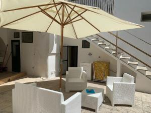 圣凯撒利亚温泉Villa Azzurra Sct的一个带遮阳伞和椅子的庭院和楼梯
