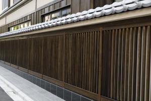 东京Onyado Nono Asakusa Natural Hot Spring的建筑物一侧的木栅栏