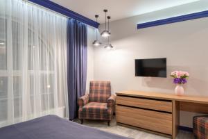 基辅Comfort House的一间卧室配有桌子、椅子和电视