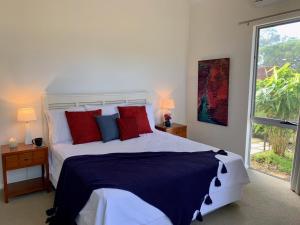 玛格丽特河原野之家住宿加早餐旅馆的一间卧室配有一张带红色和蓝色枕头的大床