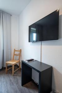 门登中央住宿加早餐旅馆的一间设有一张桌子的房间,墙上有一台电视机