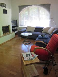 施内沃丁根Rossis Haus的带沙发和红色椅子的客厅