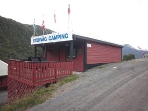 埃兹达尔Stenvåg Camping的红色的建筑,上面有为露营服务的标志