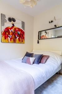 斯特拉斯堡☆ CHARMANT 2 PIECES, Calme & Lumineux - CENTRE VILLE ☆的卧室配有白色的床和墙上的绘画作品