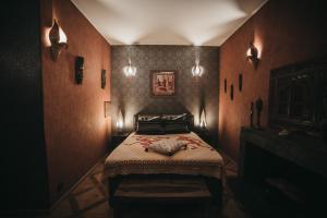 Réchicourt-le-ChâteauManoir Le Refuge的一间卧室配有一张床、一个壁炉和一个灯光