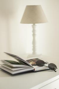 法萨诺Bed & Breakfast AMATI的书,书上放有眼镜和台灯