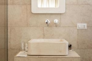 法萨诺Bed & Breakfast AMATI的浴室设有白色水槽和镜子