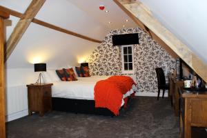 North Elmham国王头像酒店的一间卧室配有一张带橙色毯子的床