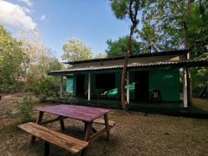 锡吉里亚尼尔米你山林小屋的绿色房子前的野餐桌