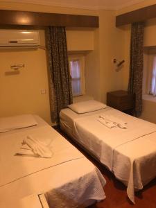 切什梅安提克里德凡酒店的配有白色床单的酒店客房内的两张床