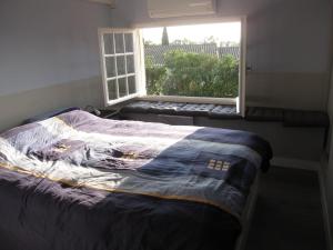 圣马迪拉莫Le Gite de Fanny的一间卧室配有一张床,窗户配有毯子