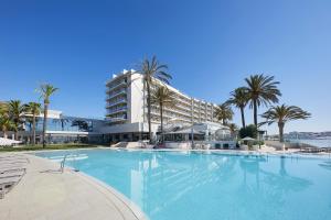 普拉亚登博萨Hotel Torre del Mar - Ibiza的一座棕榈树大型游泳池和一座建筑
