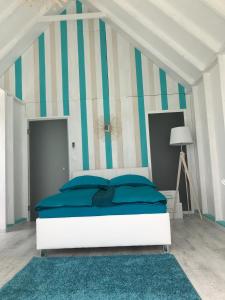 布达考拉斯LupaGlamping的一间卧室配有一张带蓝色枕头的床和条纹墙