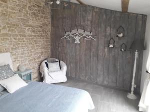 Bazoges-en-Paredsl' Oiseau Bleu的一间卧室设有一张床和木墙
