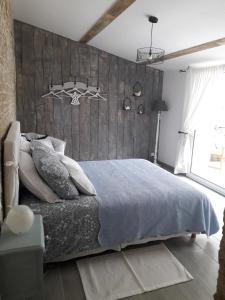Bazoges-en-Paredsl' Oiseau Bleu的一间卧室配有一张大床和木制床头板
