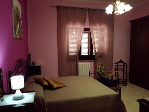 Sogliano CavourCasa Rosa的一间卧室配有一张粉红色的墙壁和窗户。