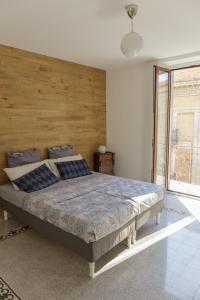 蒙泰内罗迪比萨恰Corte Soriano的一间卧室配有一张大床和木制床头板