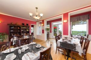 拉马巴耶奥博鲜花酒店的一间设有桌椅和红色墙壁的餐厅