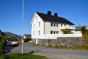 雷讷The Manor House in Hamnøy的街上有黑屋顶的白色房子