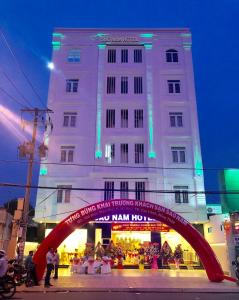 Cao LãnhKhách sạn SAO NAM的一座白色的大建筑,前面有一个红色拱门