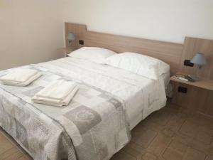 莱韦拉诺La casa di Mela的一张白色的大床,上面有两条白色毛巾