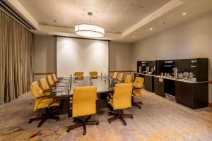 西班牙港特立尼达凯悦酒店的一间会议室,配有长桌子和黄色椅子