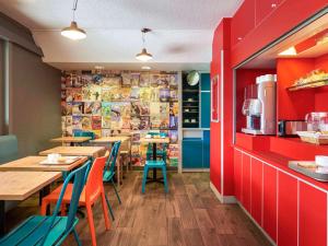 ChangéhotelF1 Laval的一间带桌椅和红色墙壁的餐厅
