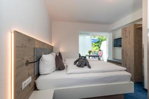 康斯坦茨霍尔泽旅舍的卧室配有一张白色大床和床头板