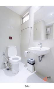曼谷普广场旅馆的白色的浴室设有卫生间和水槽。