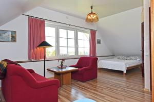 普拉特利艾Vila RUNA的客厅配有2把红色椅子和1张床