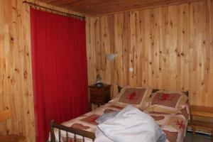 普华露RDC小木屋的一间卧室配有床和红色窗帘
