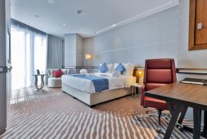 多哈VIP Hotel Doha Qatar的配有一张床和一张书桌的酒店客房