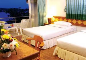 甲米镇甲米河酒店的酒店客房,设有两张床和一张鲜花桌。