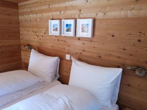TrinCasa Alva的配有木墙和白色枕头的客房内的两张床