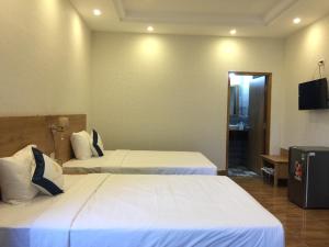 金瓯Thanh Truc Hotel Ca Mau的配有电视的酒店客房内的两张床