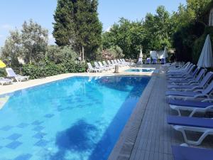 Gemlik阿塔迈尔多加度假酒店的一个带椅子和遮阳伞的大型游泳池